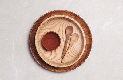 Photo of Wooden spoons and dishes on grey table, top view. Cooking utensils