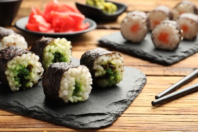 Tasty sushi rolls served on wooden table, closeup