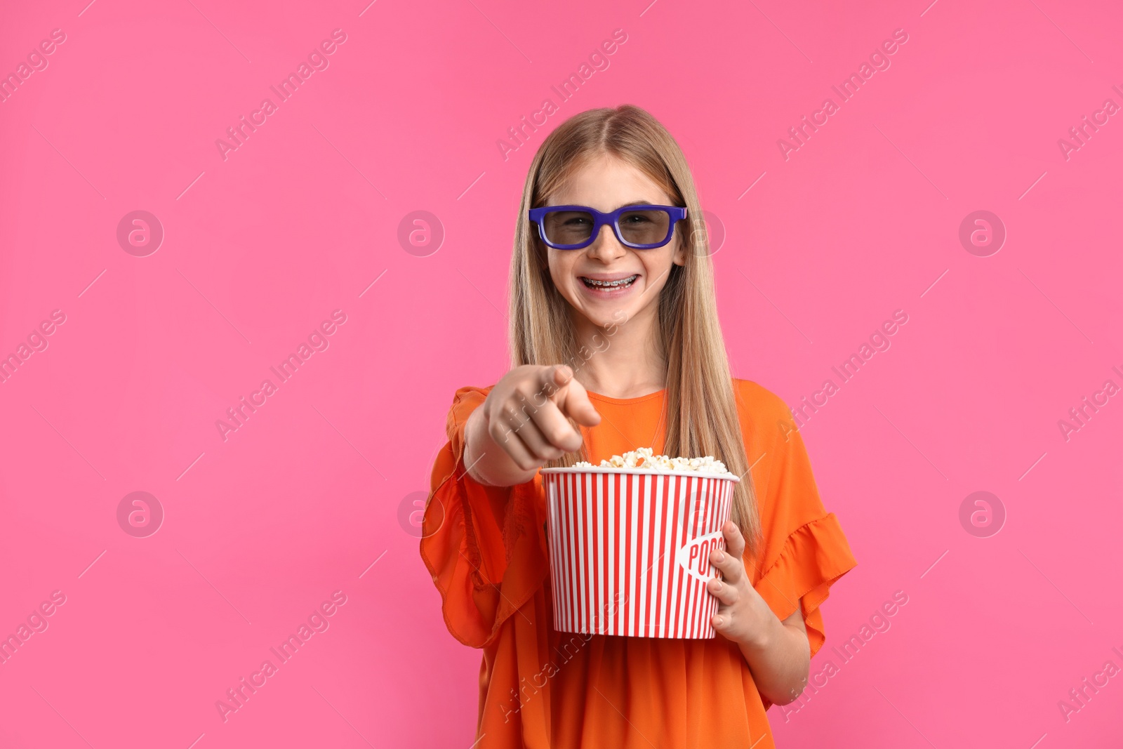 Photo of Teenage girl with 3D glasses and popcorn during cinema show on color background
