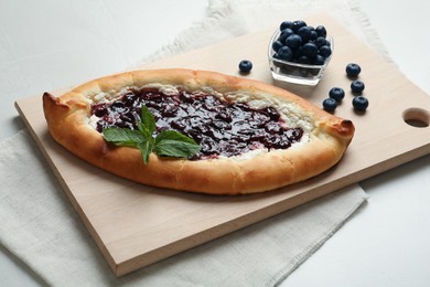 Photo of Delicious sweet cottage cheese pastry with cherry jam on light table