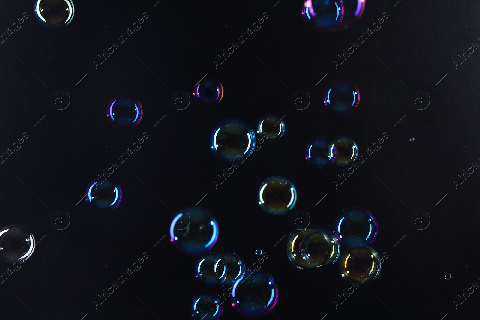 Photo of Beautiful transparent soap bubbles on dark background