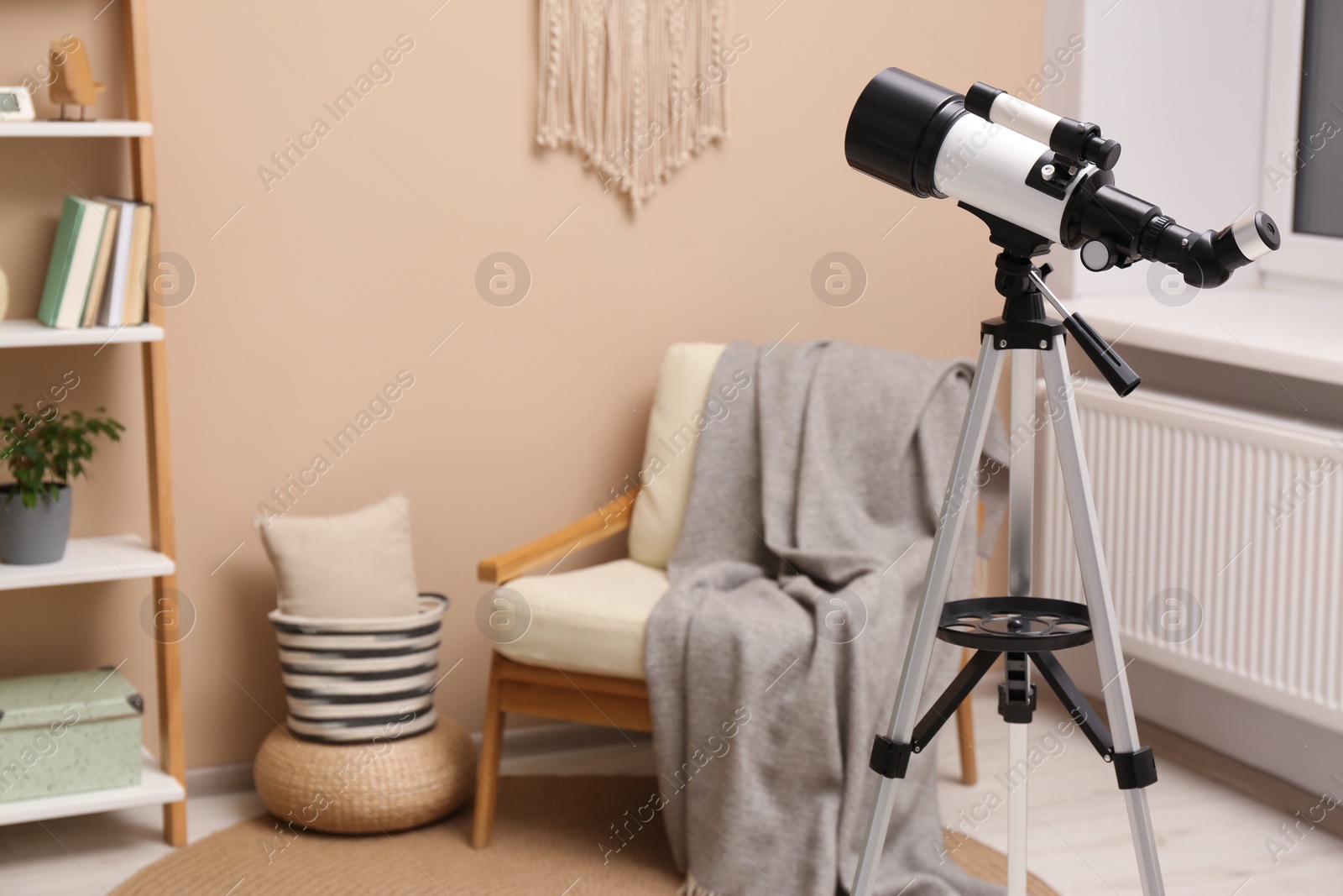 Photo of Tripod with modern telescope in stylish room. Space for text