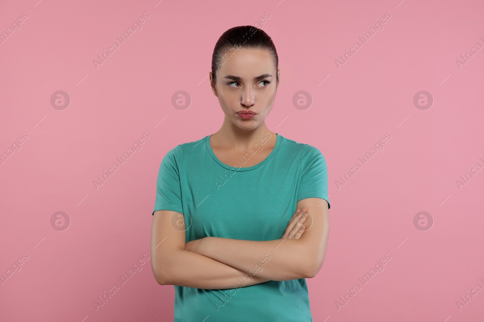 Photo of Portrait of resentful woman with crossed arms on pink background