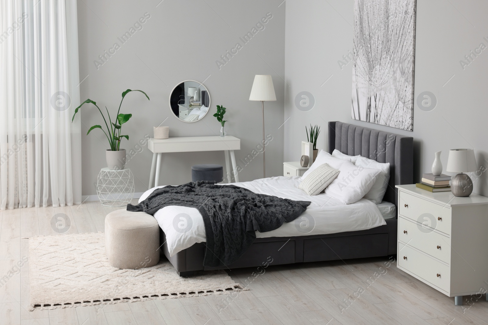 Photo of Stylish bedroom interior with large comfortable bed and dressing table