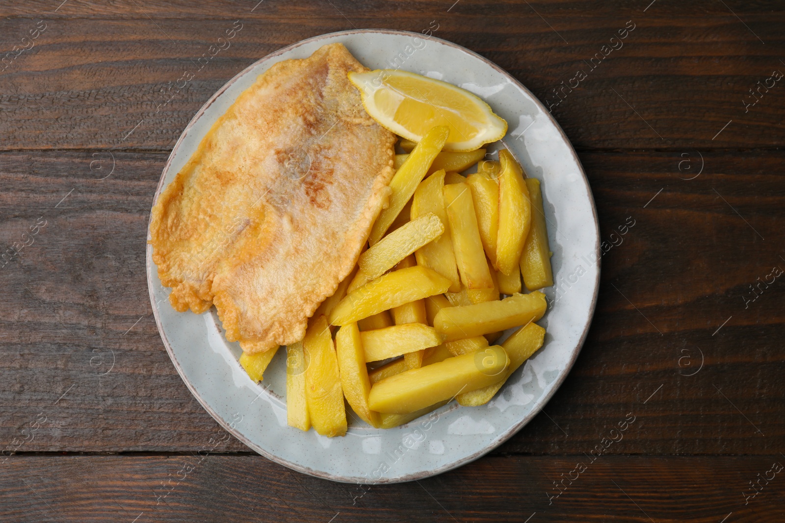 Photo of Delicious fish and chips on wooden table, top view