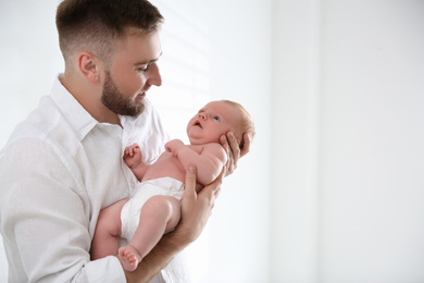 Photo of Father with his newborn son on light background. Space for text