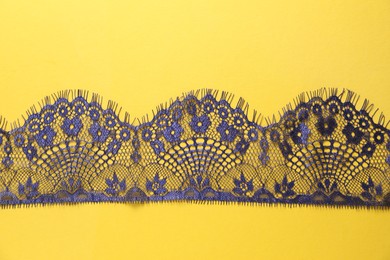 Blue lace on yellow background, top view