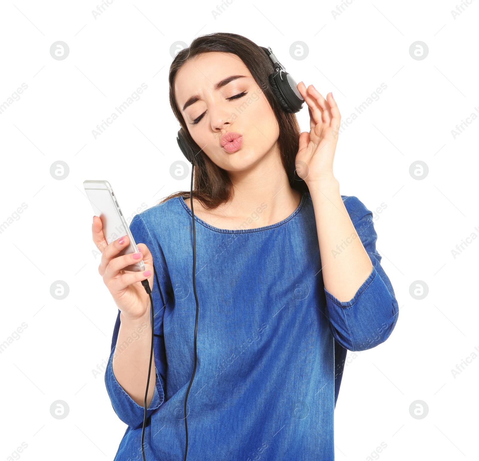 Photo of Beautiful young woman listening to music on mobile phone against white background