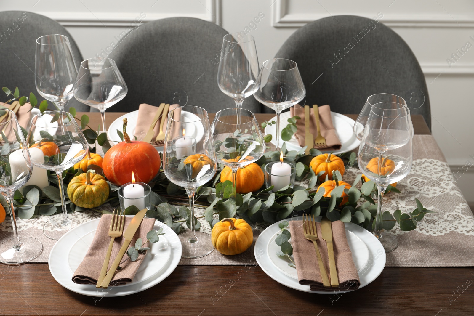 Photo of Beautiful autumn table setting. Plates, cutlery, glasses, pumpkins and floral decor