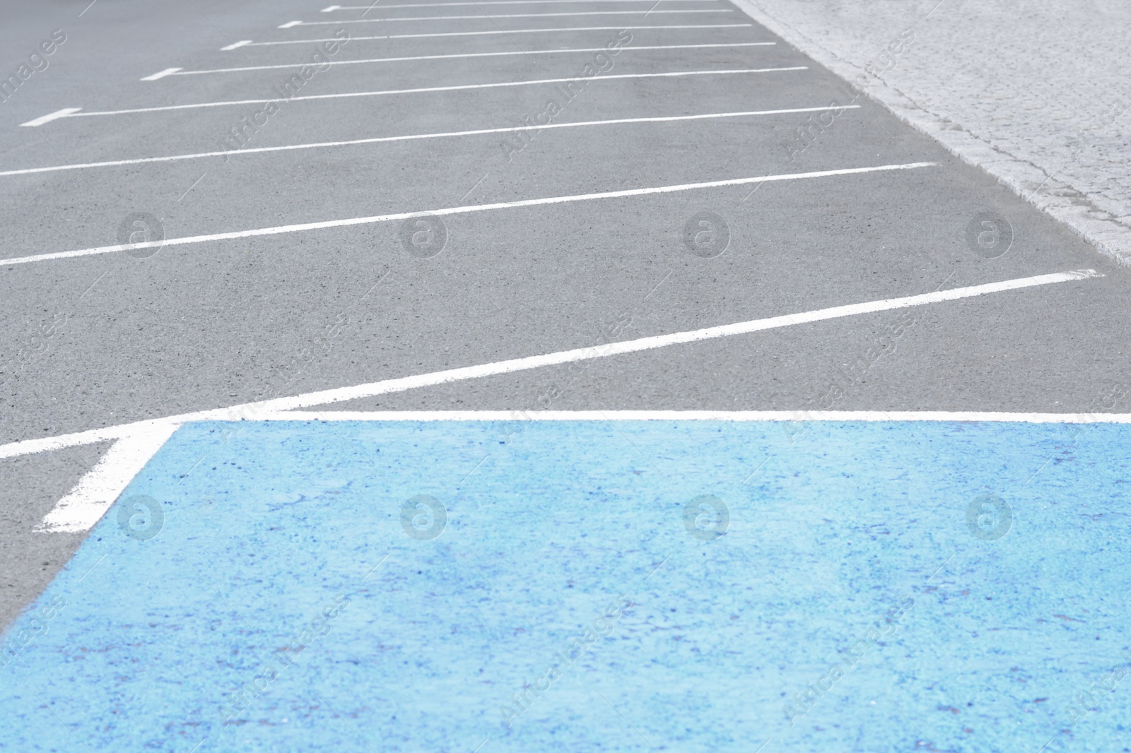 Photo of Empty outdoor parking lot with painted markings on asphalt