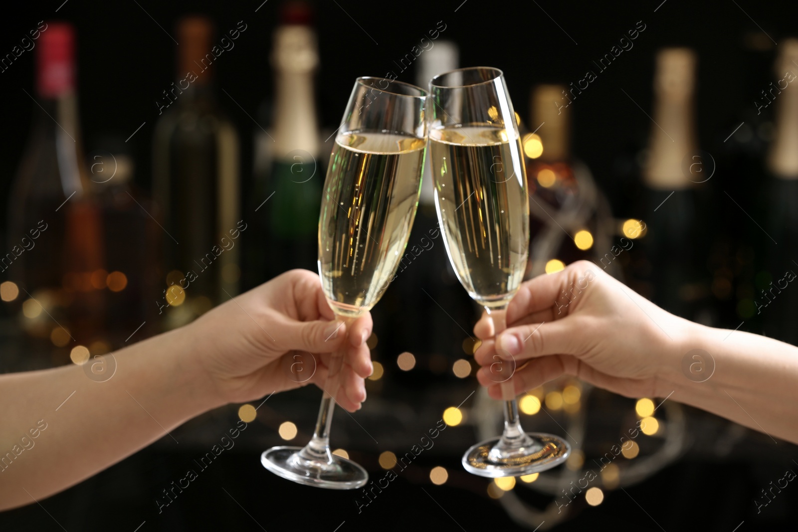 Photo of People clinking glasses of champagne on blurred background, closeup