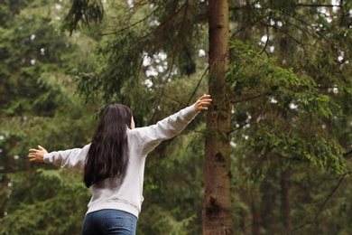 Woman on walk in beautiful coniferous forest