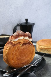 Round croissants with cream and chocolate chips served on grey table. Tasty puff pastry