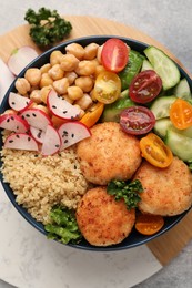 Photo of Delicious vegan bowl with chickpeas, cutlets and radish on grey table, top view