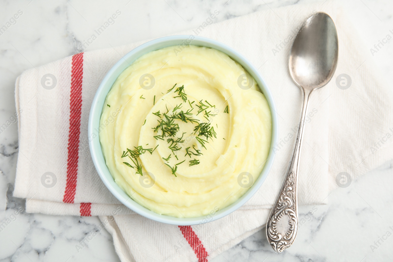 Photo of Freshly cooked homemade mashed potatoes with spoon and napkin, top view