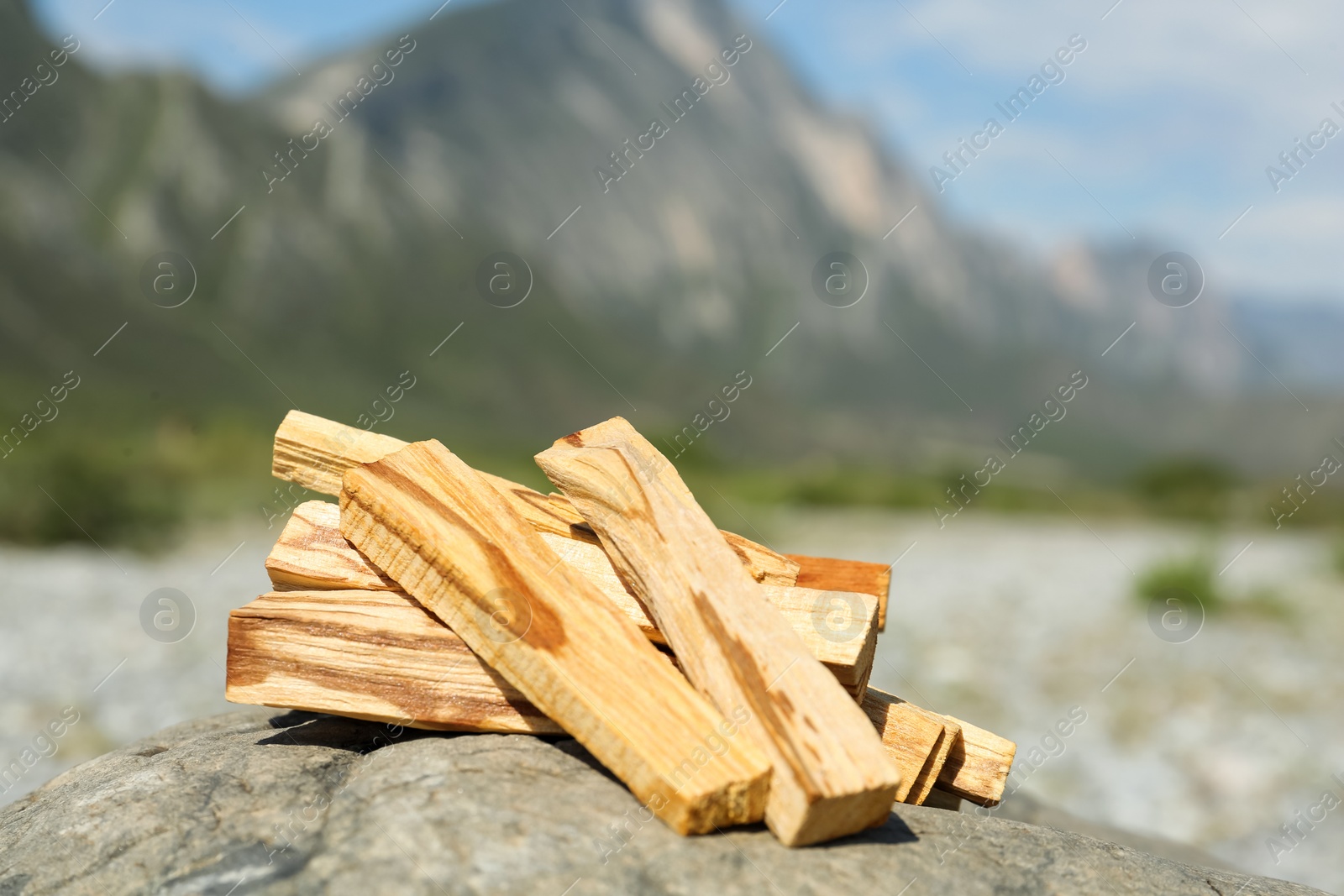 Photo of Many palo santo sticks on stone surface in high mountains, closeup