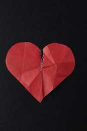 Photo of Crumpled torn paper heart on black background, top view. Breakup concept