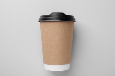 Photo of One paper cup on light grey background, top view. Coffee to go