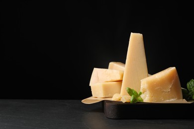 Photo of Delicious parmesan cheese with basil on grey table. Space for text