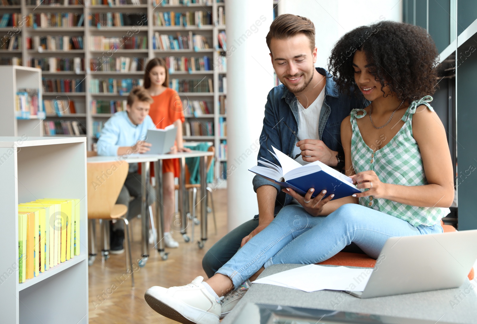 Photo of Young people studying together in modern library