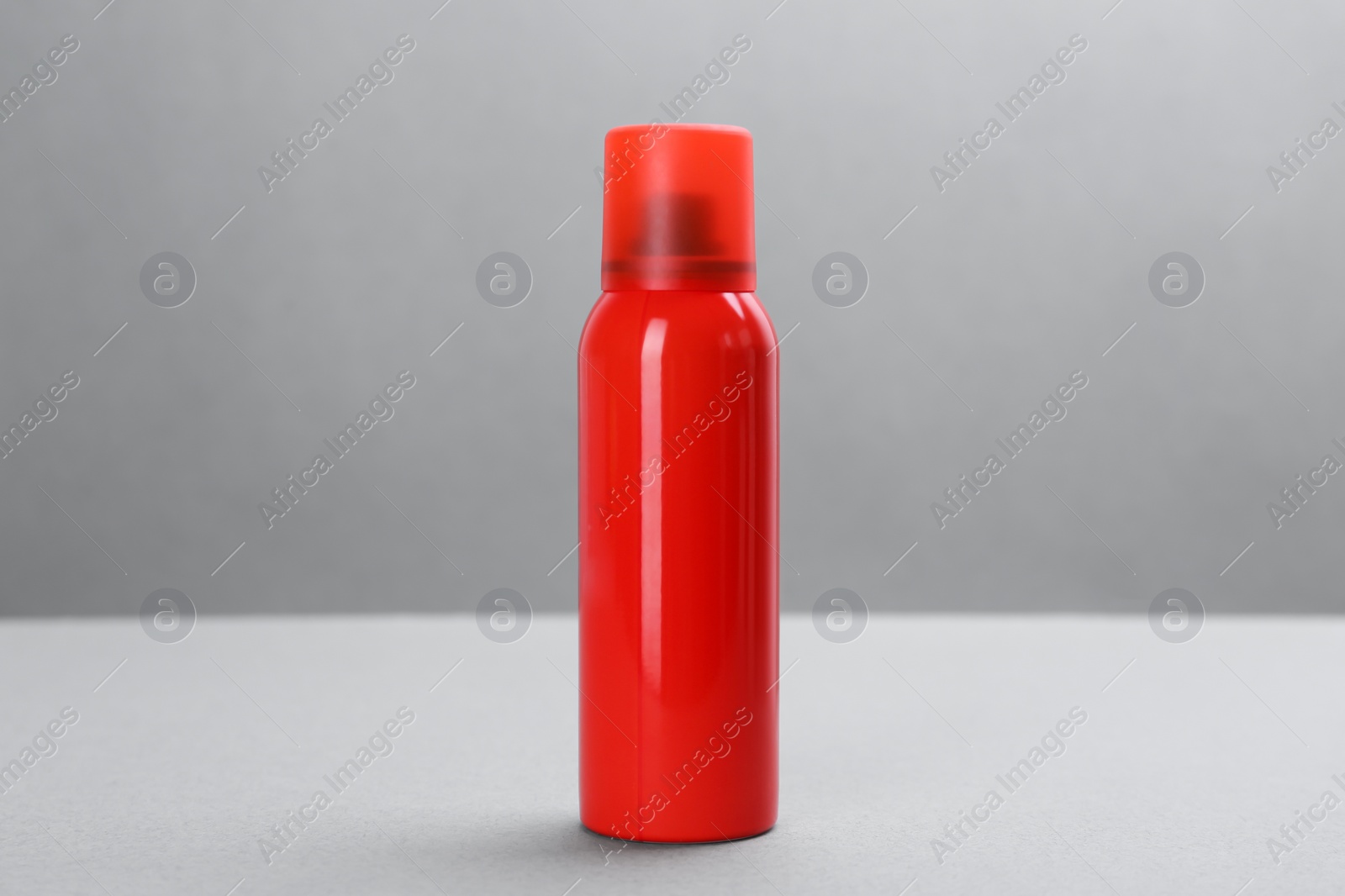 Photo of Bottle with insect repellent spray on grey background