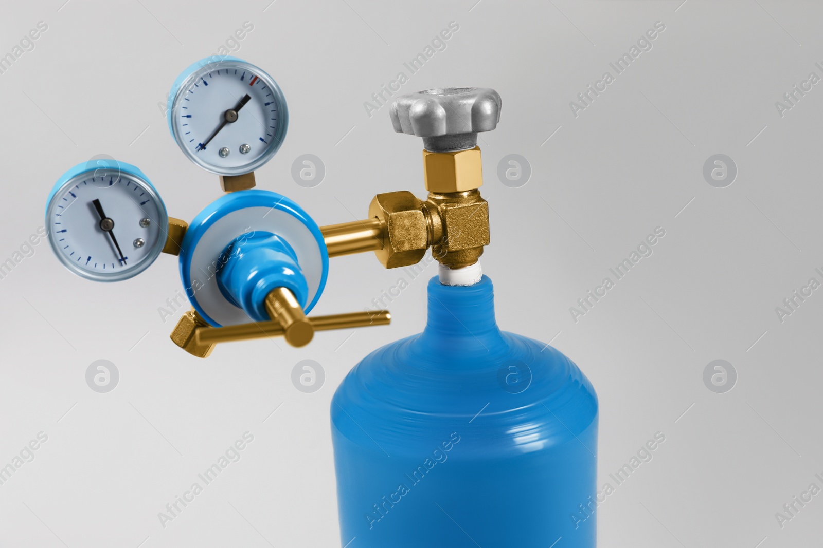 Photo of Oxygen tank on light grey background, closeup. Medical equipment