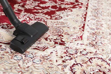 Hoovering carpet with modern vacuum cleaner indoors. Space for text