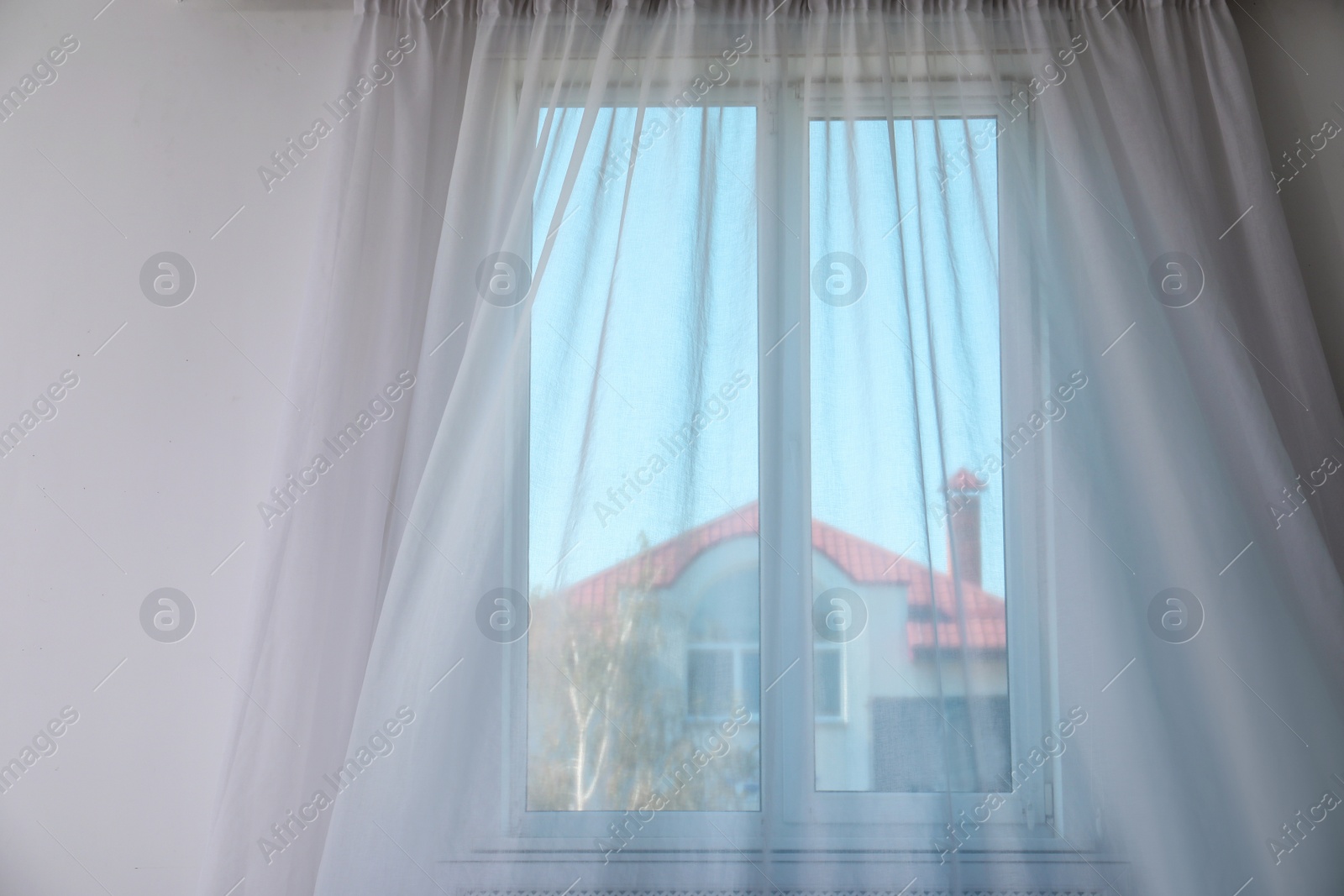 Photo of Window with fluttering curtain indoors. Home interior