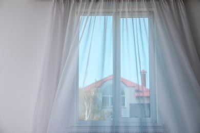 Photo of Window with fluttering curtain indoors. Home interior