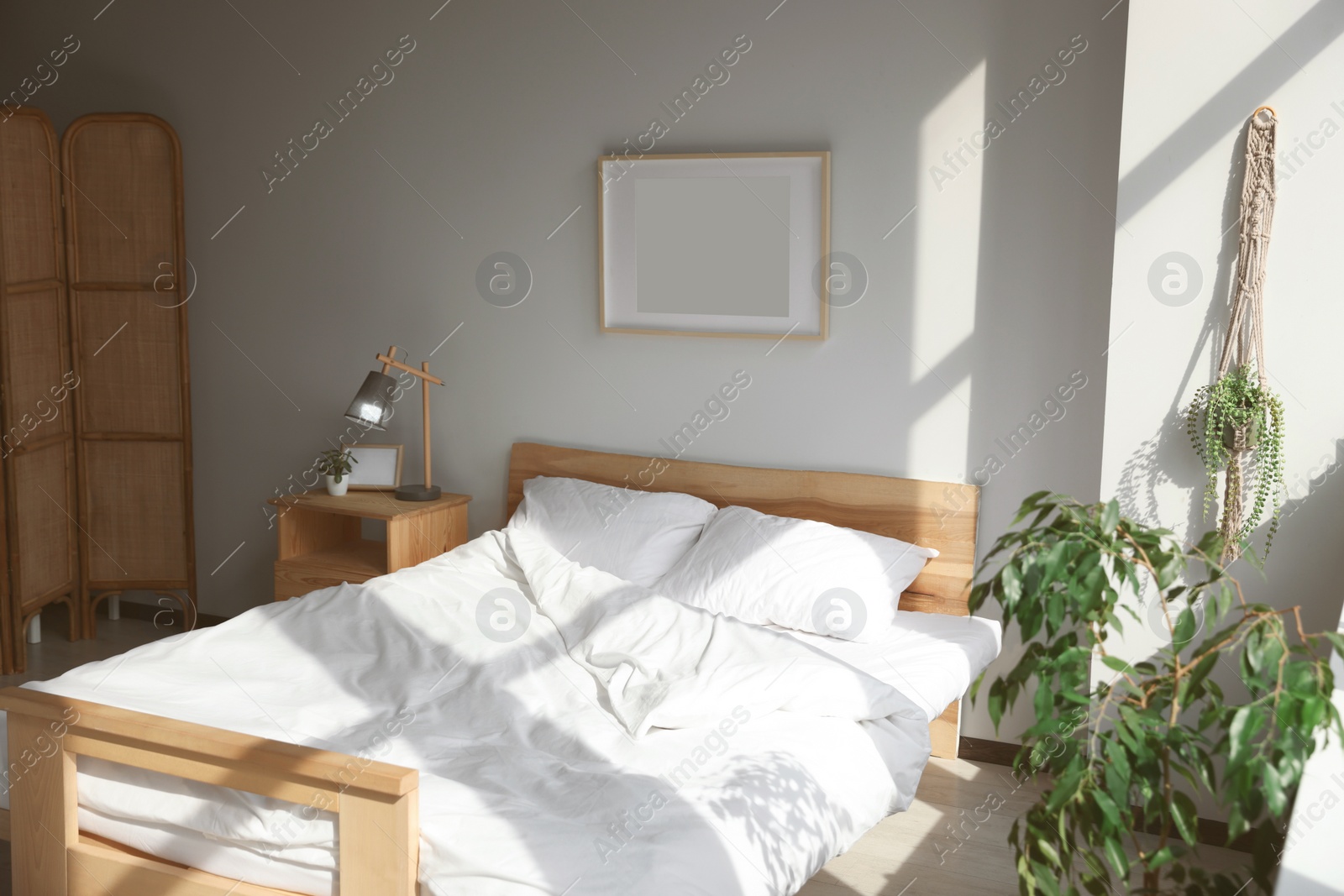 Photo of Large comfortable bed with soft pillows and blanket indoors