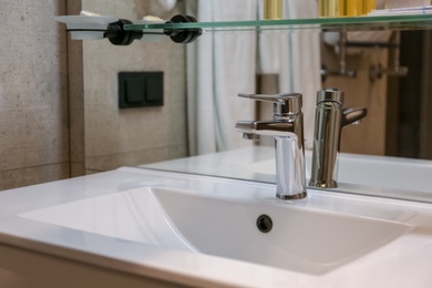 Photo of Chrome tap and white sink in bathroom