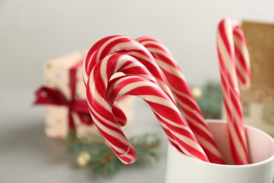 Photo of Sweet Christmas candy canes in cup, closeup view