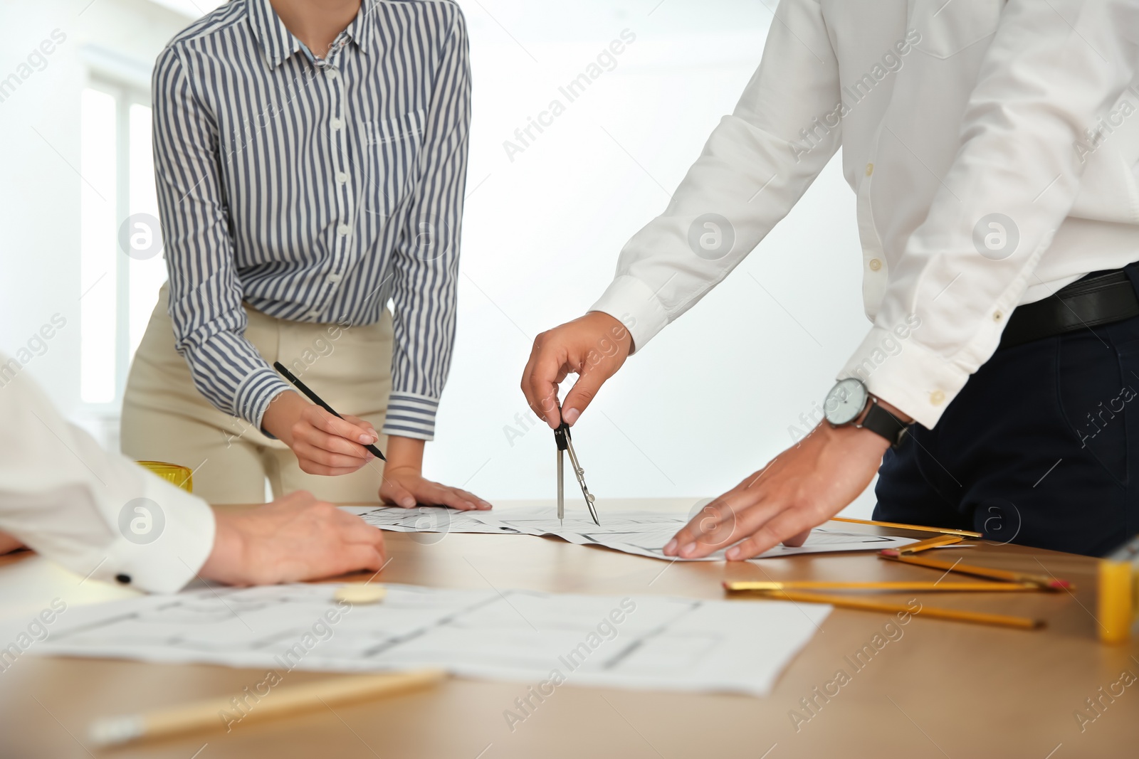 Photo of People working with construction drawings at table, closeup