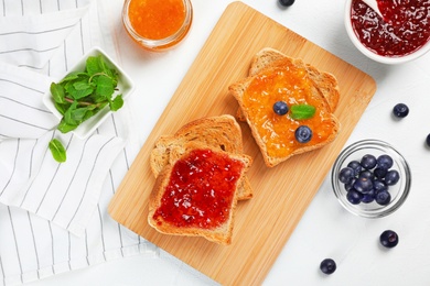 Photo of Toasts with sweet jam on light background, flat lay composition