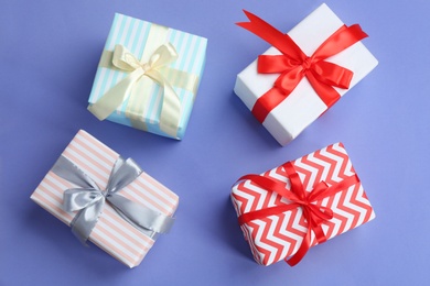 Photo of Beautifully decorated gift boxes on color background, top view