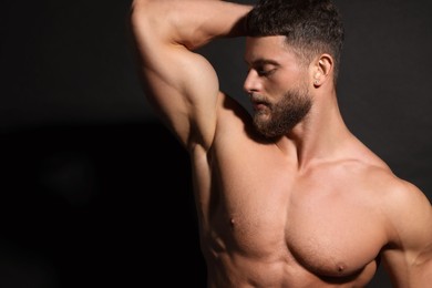 Photo of Handsome muscular man on black background. Sexy body