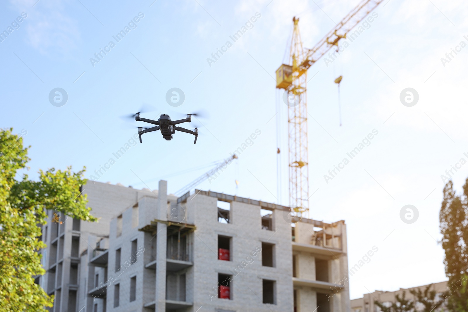 Photo of Modern drone flying at building site. Aerial survey