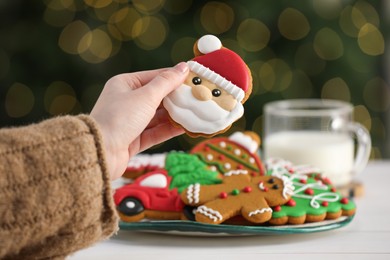 Photo of Woman with decorated Christmas cookies at table, closeup