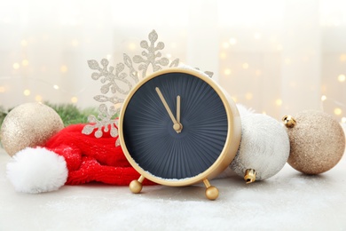 Photo of Clock, festive decor and Santa hat on table. Christmas countdown