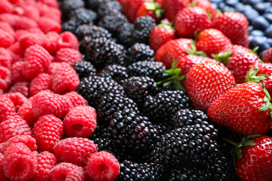 Photo of Mix of different ripe tasty berries as background, closeup view