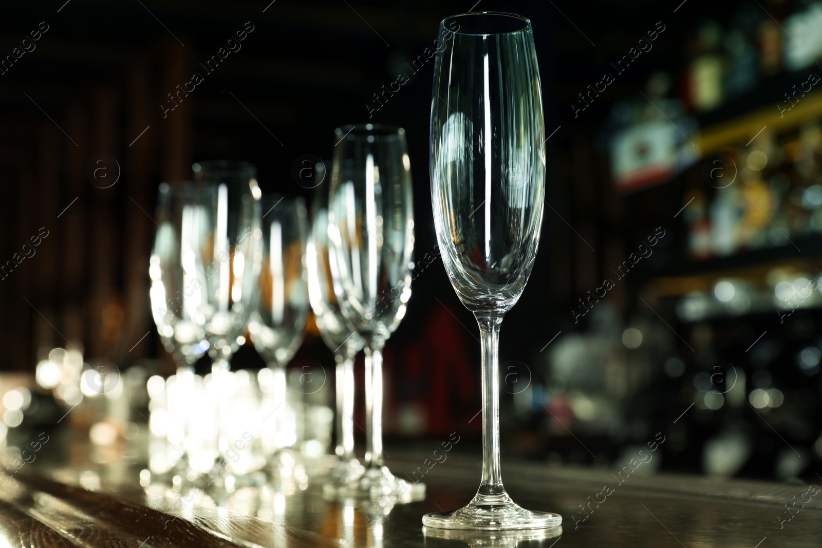 Photo of Empty clean champagne glass on counter in bar. Space for text