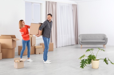 Photo of Couple with moving box in their new house