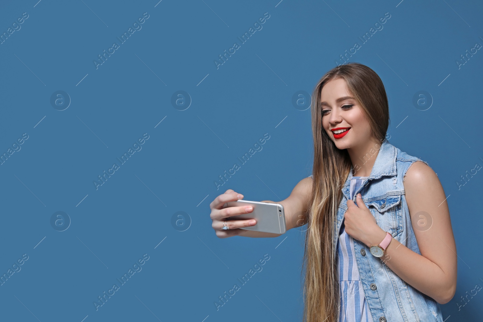 Photo of Attractive young woman taking selfie on color background