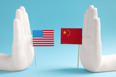 Paper USA and China flags on light blue background. Trade war
