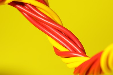 Electrical wires on yellow background, closeup view