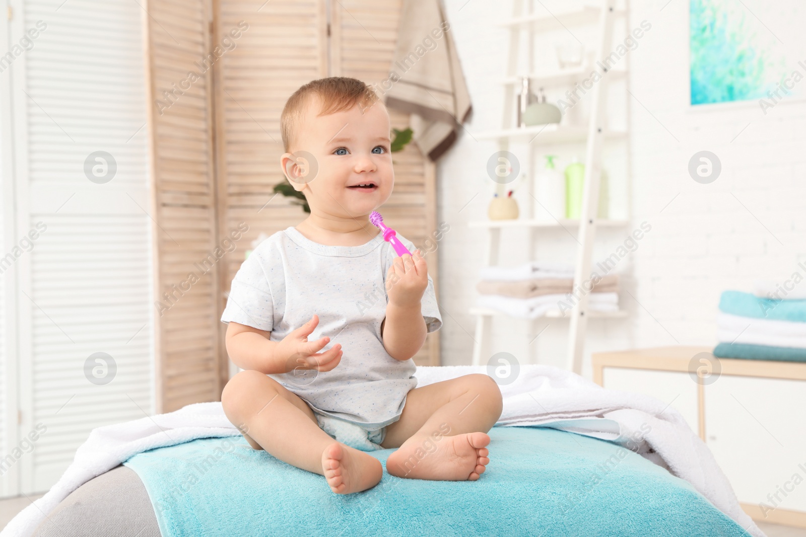 Photo of Cute little boy with toothbrush on blurred background