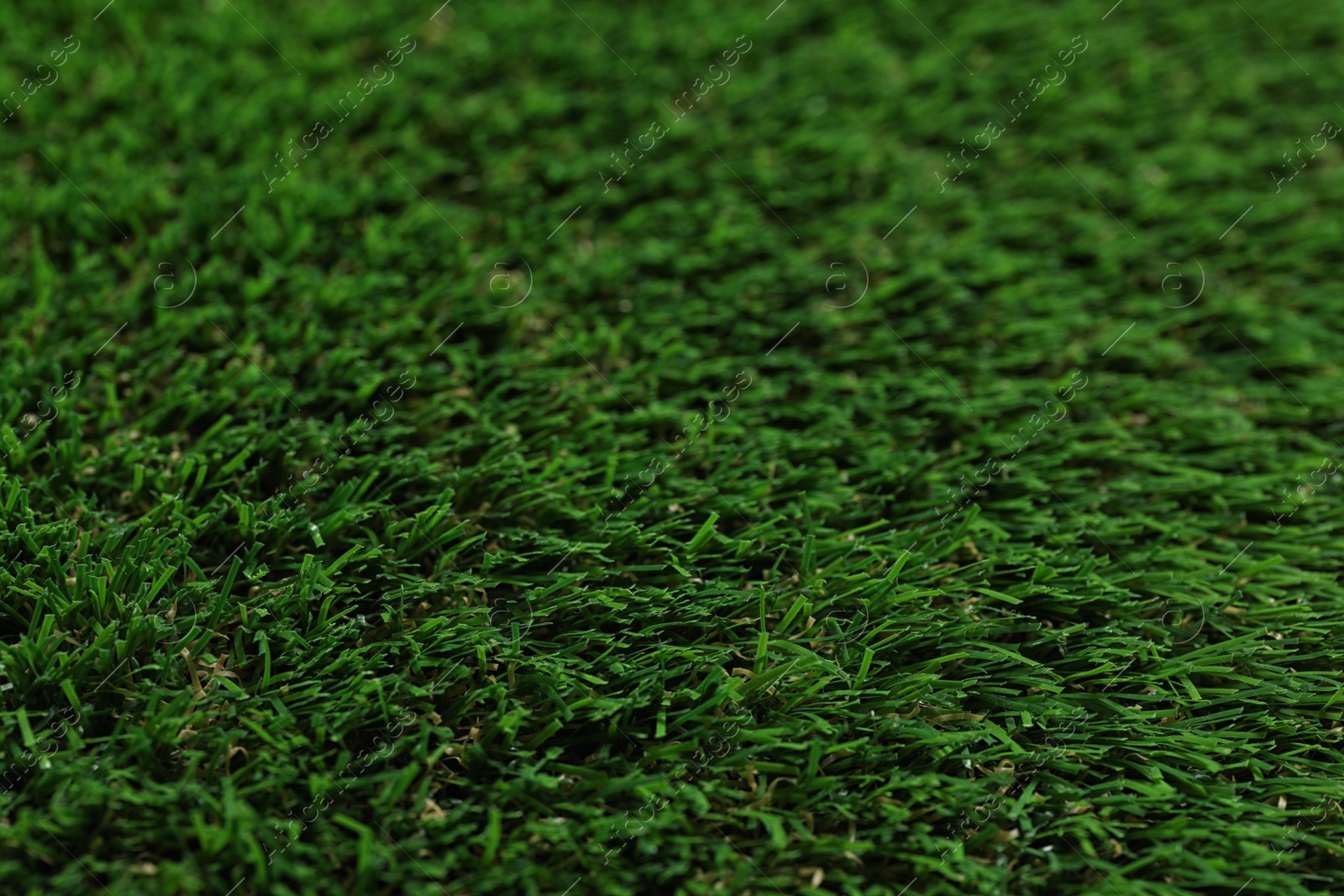 Photo of Green artificial grass texture as background, closeup