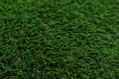 Photo of Green artificial grass texture as background, closeup