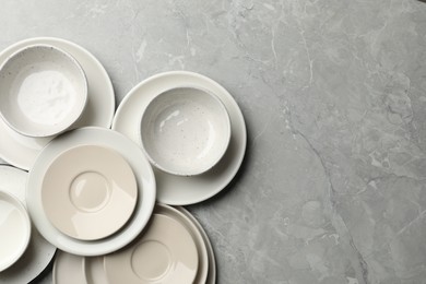 Photo of Set of clean tableware on grey table, flat lay. Space for text