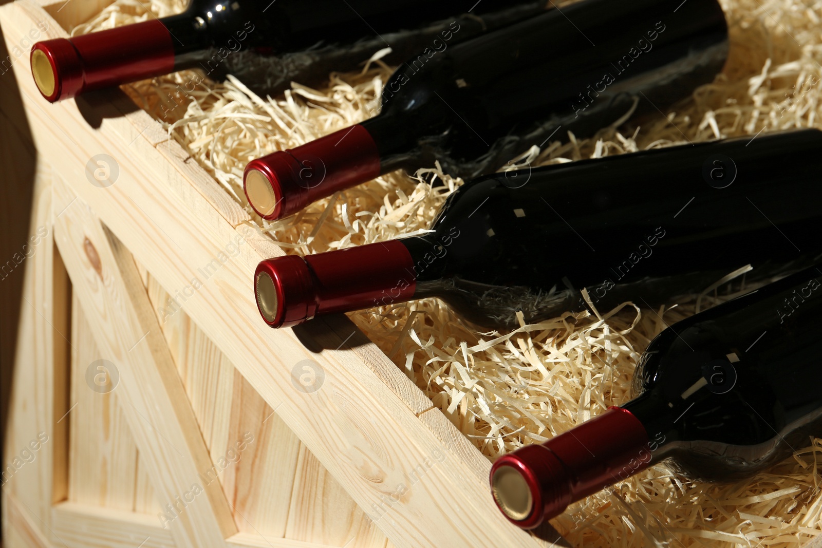 Photo of Wooden crate with bottles of wine, closeup